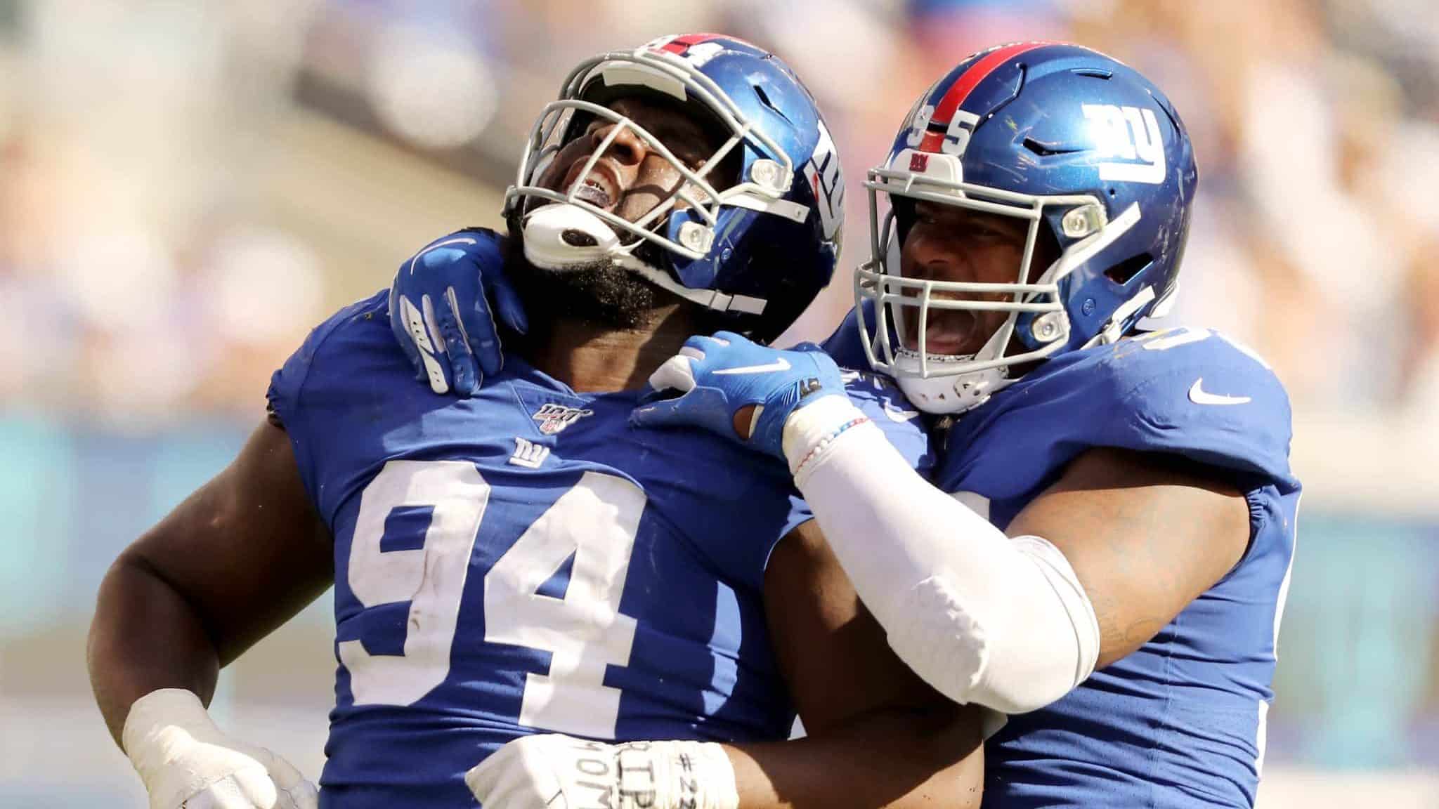 EAST RUTHERFORD, NEW JERSEY - SEPTEMBER 29: Dalvin Tomlinson #94 and B.J. Hill #95 of the New York Giants celebrate after they sacked Dwayne Haskins Jr. #7 of the Washington Redskins at MetLife Stadium on September 29, 2019 in East Rutherford, New Jersey.