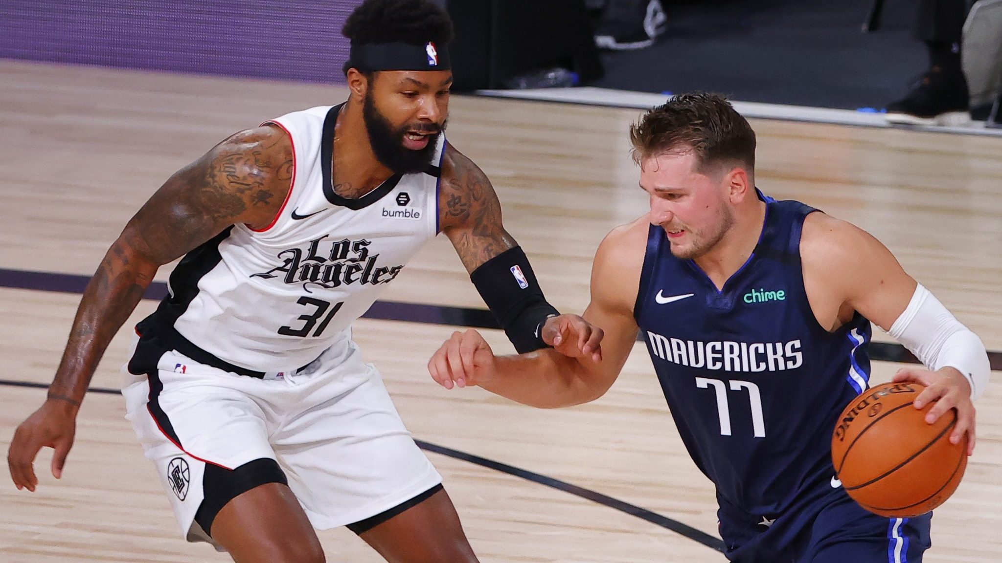 LAKE BUENA VISTA, FLORIDA - AUGUST 23: Luka Doncic #77 of the Dallas Mavericks drives against Marcus Morris Sr. #31 of the LA Clippers during the first quarter in Game Four of the Western Conference First Round during the 2020 NBA Playoffs at AdventHealth Arena at ESPN Wide World Of Sports Complex on August 23, 2020 in Lake Buena Vista, Florida. NOTE TO USER: User expressly acknowledges and agrees that, by downloading and or using this photograph, User is consenting to the terms and conditions of the Getty Images License Agreement.