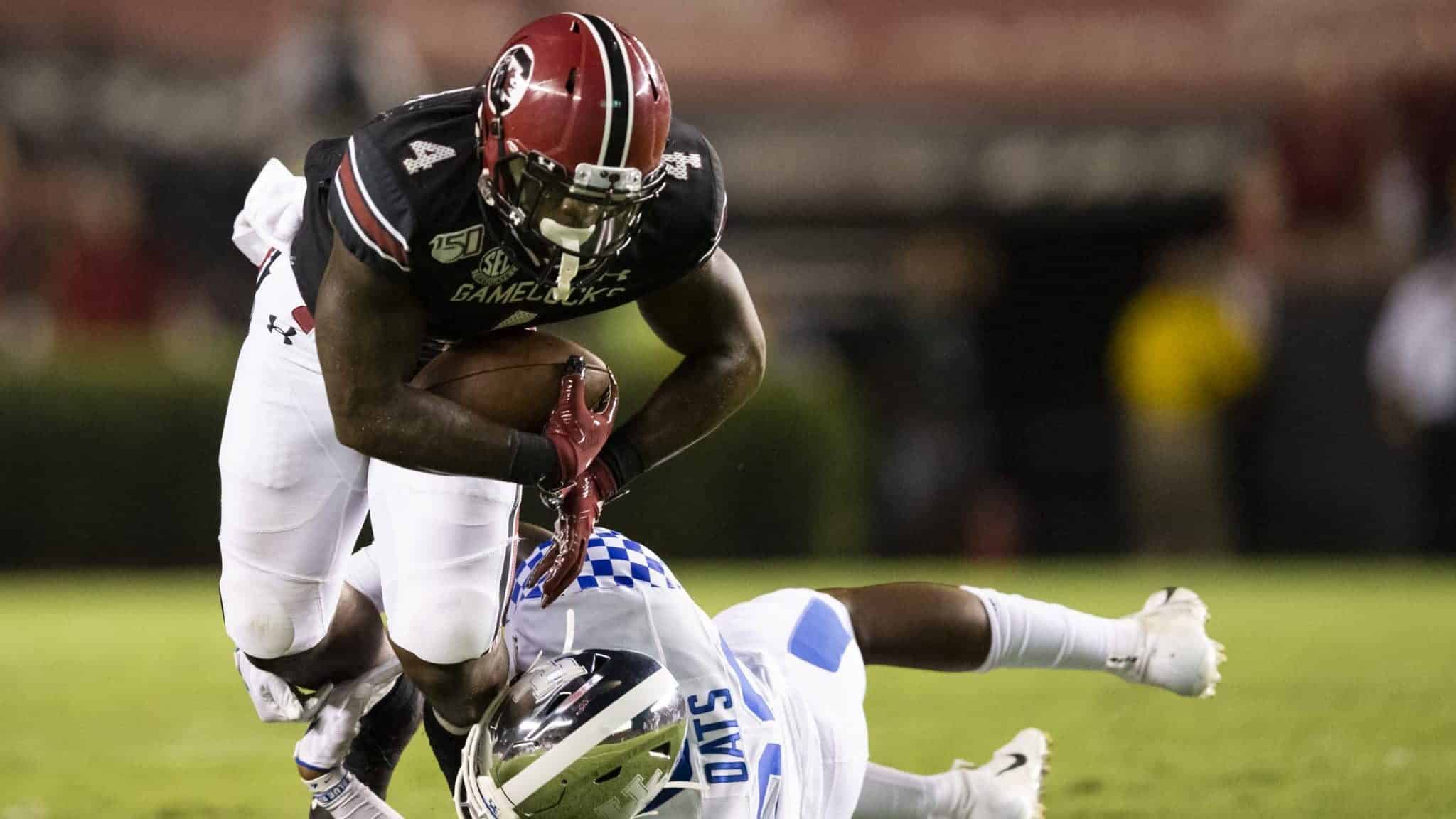 COLUMBIA, SC - SEPTEMBER 28: Tavien Feaster #4 of the South Carolina Gamecocks is tripped up by Chris Oats #22 of the Kentucky Wildcats during the first half of a game at Williams-Brice Stadium on September 28, 2019 in Columbia, South Carolina.